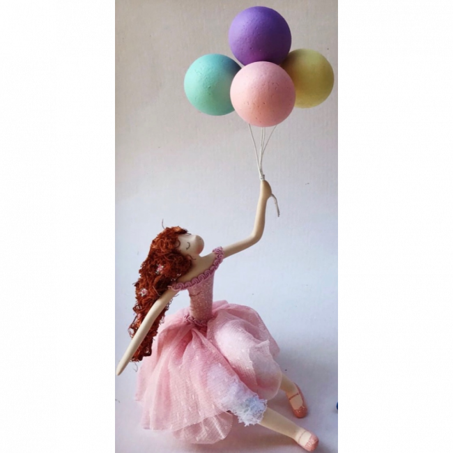 Menina de vestido rosa, com um cacho de balão
